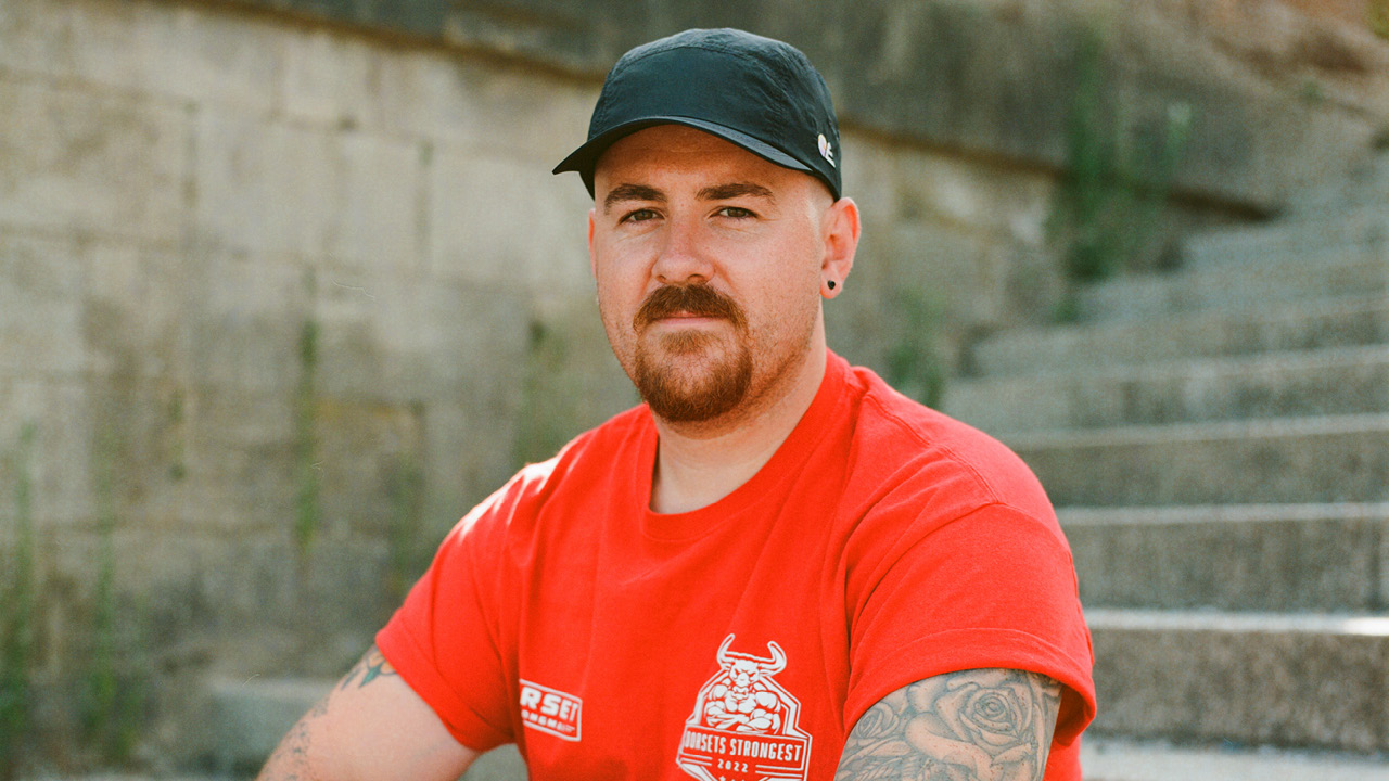 a man in a black cap, wearing a red tshirt